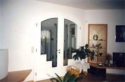 Wohnzimmer; 2-fl&uuml;gelige Segmentt&uuml;r in Esche &ndash; wei&szlig;, Glasvitrine in Trapezform