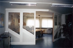 Raumteiler; Teilung von B&uuml;ror&auml;umen, innen Buche furniert, au&szlig;en Esche &ndash; wei&szlig;, F&uuml;llungen in Edelstahloptik; Schiebet&uuml;ren &ouml;ffnen synchron